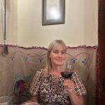 Chef Deb in restaurant in Spain, drinking a glass of wine