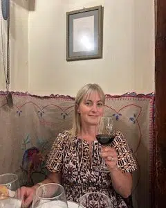 Chef Deb in restaurant in Spain, drinking a glass of wine