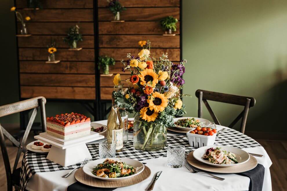 A table decorated with sunflowers and Chef Deb's summer meals.