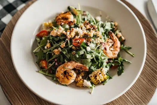 Upclose photo of shrimp and corn salad with greens. 